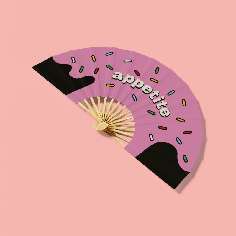 Branded merchandise wooden printed fan with pink background.